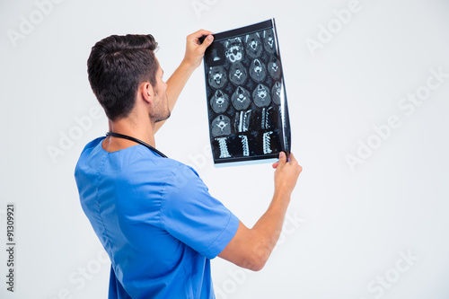 Back view portrait of a male doctor looking at x-ray picture