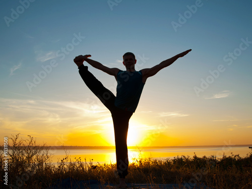 Man in yoga hasta padangushasana  pose standing outdoor