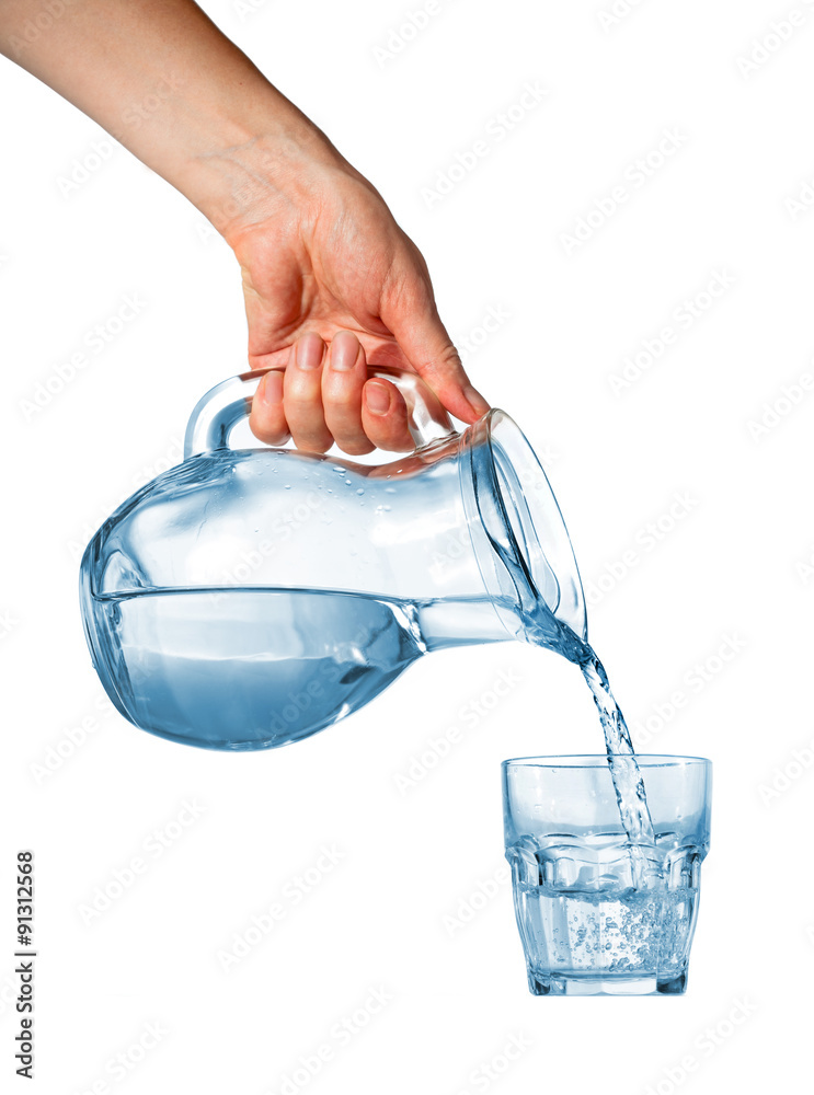 Hand pouring water from glass pitcher Stock Photo