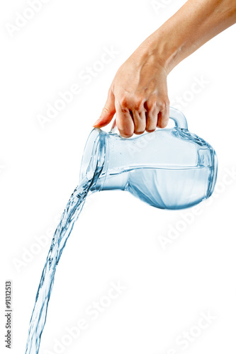 Hand pouring water from glass jug photo