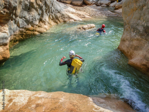 People in the water of a canyon in summer, canyoning in Barranco Oscuros, Sierra de Guara, Aragon, Spain photo