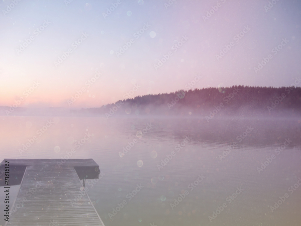 abstract photo of misty and foggy lake at morning sunrise.
