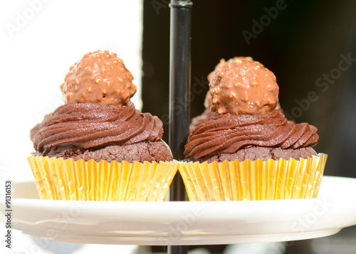 Chocolate cupcakes with frosting and Fererro Rocher on top photo