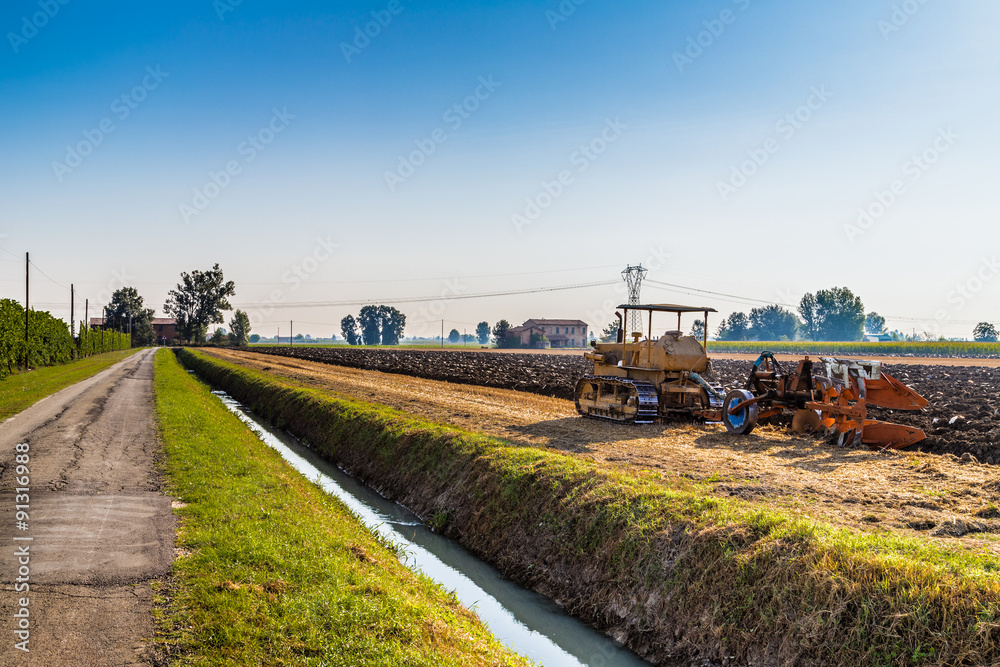 old tractor plowing a field
