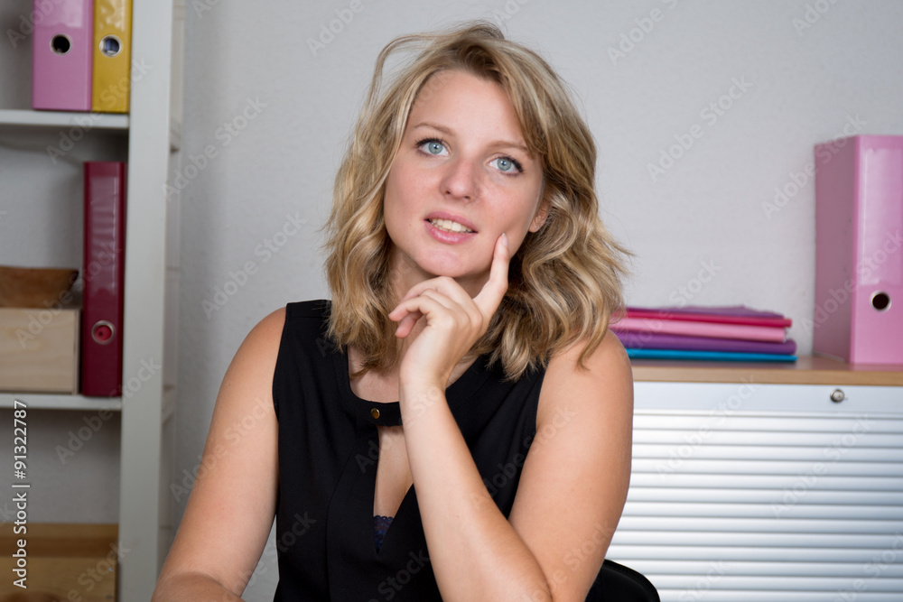 Beautiful pensive elegant blond business woman sitting in office