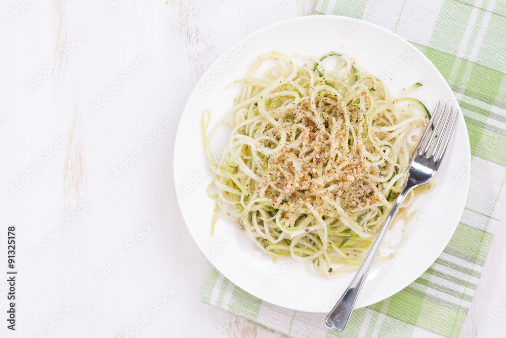 Vegetarian pasta with zucchini and nuts, top view