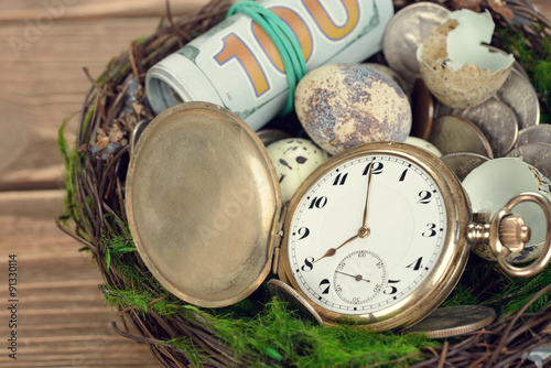 Watches, money, and eggs in a nest