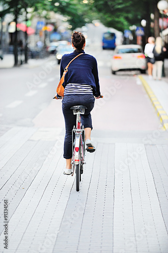 Woman on bike in green summer city