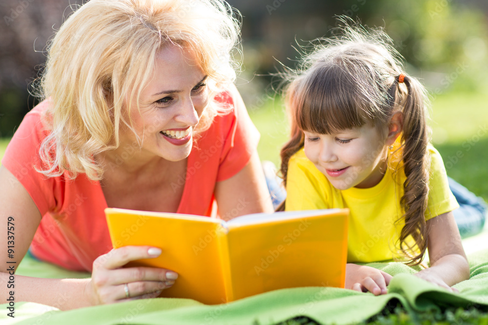 Mother and daughter reading a book at the park. Mother and daughter reading a book at the park.