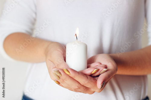 Body part - woman with white candle in hands