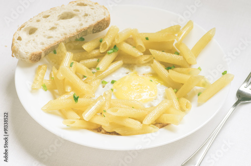 Penne pasta with fresh herbs and fried eggs