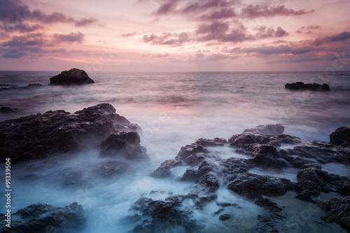 Seashore with misty water at sunset