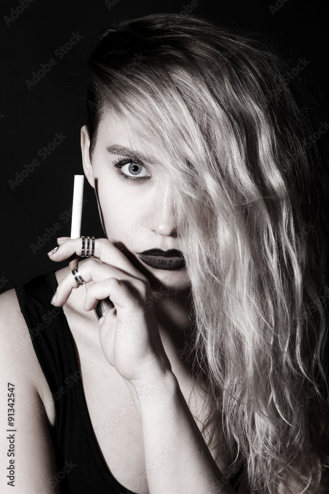 Beautiful young woman smoking a cigarette Beautiful young woman smoking a cigarette