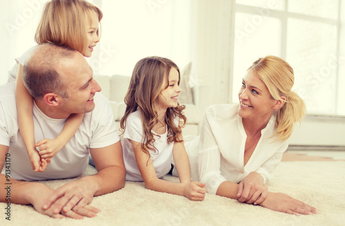 parents and two girls lying on floor at home