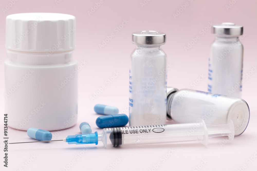 The set of medicine bottles, blue pills and injection syringe The set of medicine bottles, blue pills and injection syringe