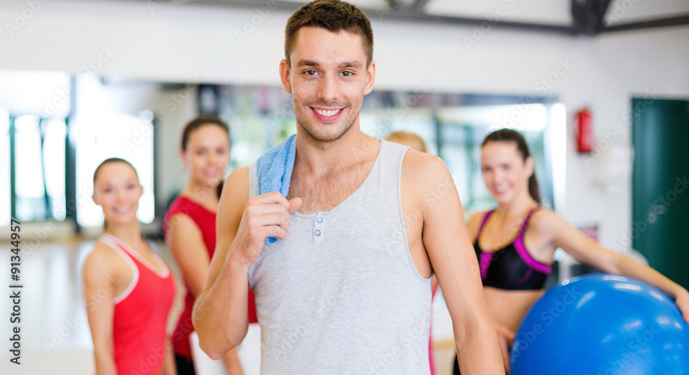 smiling man standing in front of the group in gym smiling man standing in front of the group in gym