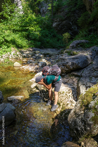 Hiker washing in a mountain river