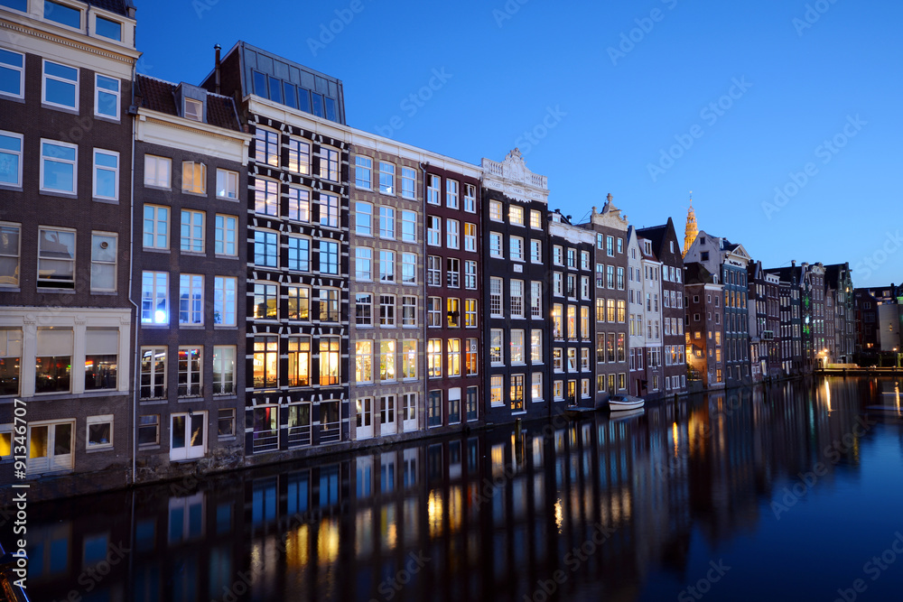 Typische Häuserfront vor Gracht in Amsterdam bei Nacht