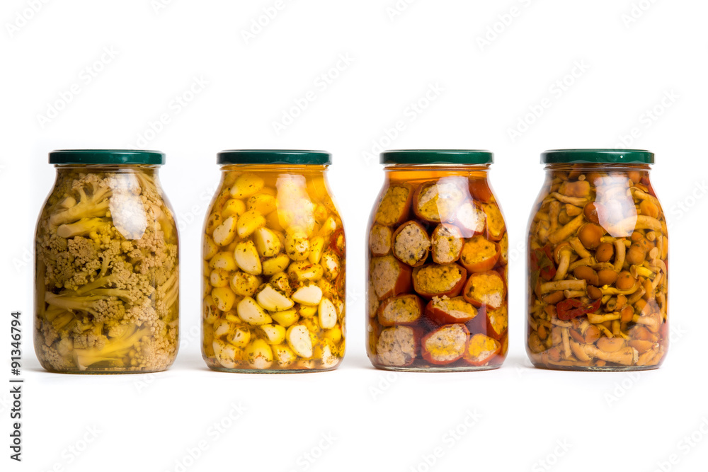 Vasi di vetro allineati con verdure sott’olio isolati su sfondo bianco Vasi di vetro allineati con verdure sott’olio isolati su sfondo bianco