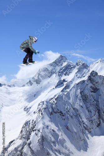 Flying snowboarder on mountains