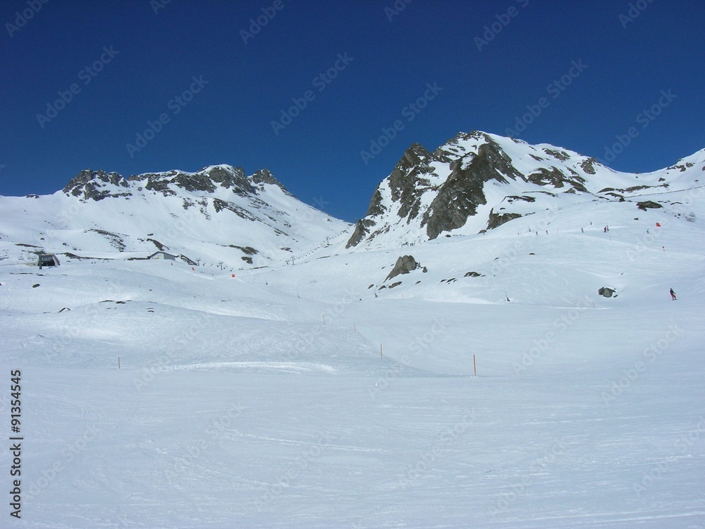 Beautiful snowy winter landscape in a mountain ski resort, on a sunny afternoon. Ski slopes.