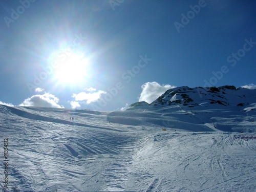 Beautiful idyllic snowy winter landscape in a mountain ski resort, on a sunny afternoon.