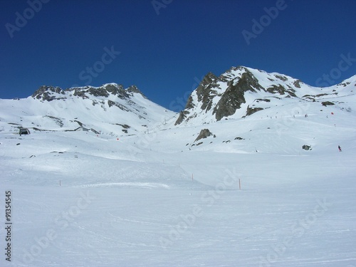Beautiful snowy winter landscape in a mountain ski resort, on a sunny afternoon. Ski slopes. © Jasmina