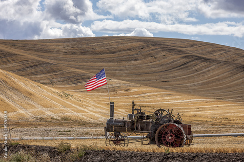 Steam engine and flag in field.