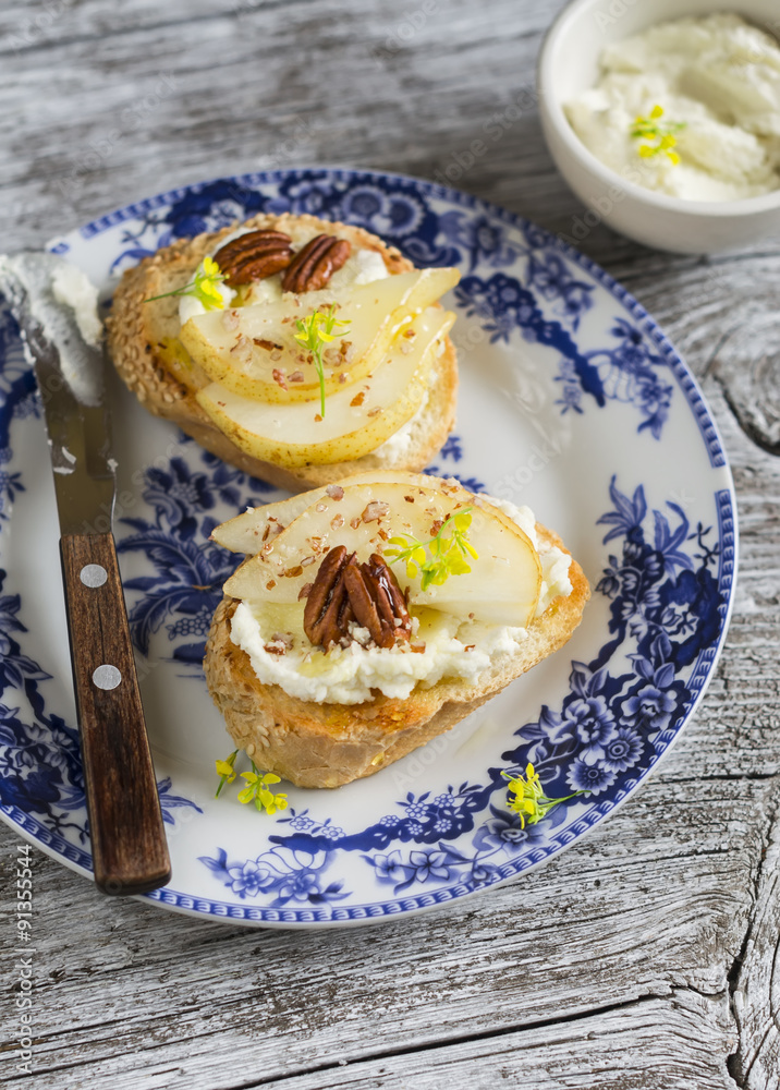 bruschetta with cheese, pear, honey and nuts on the oval plate on a light wooden surface bruschetta with cheese, pear, honey and nuts on the oval plate on a light wooden surface