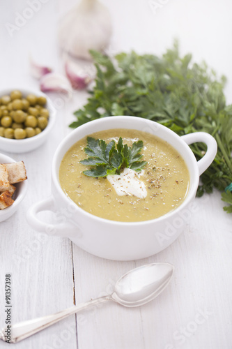 A delicious pea cream with aromatic spices on a wooden table.