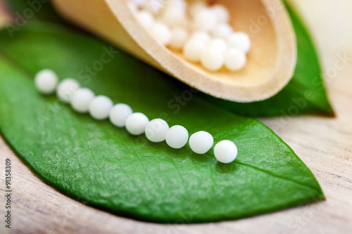 Homeopathic pills on leaf.