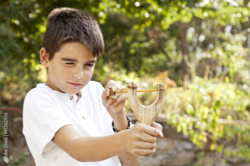 boy with slingshot outdoors