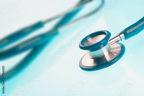 Stethoscope on blue, reflective background