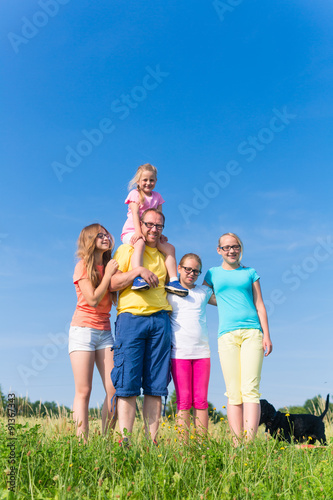 Familie steht auf der Wiese - Vater mit Kindern im Gras