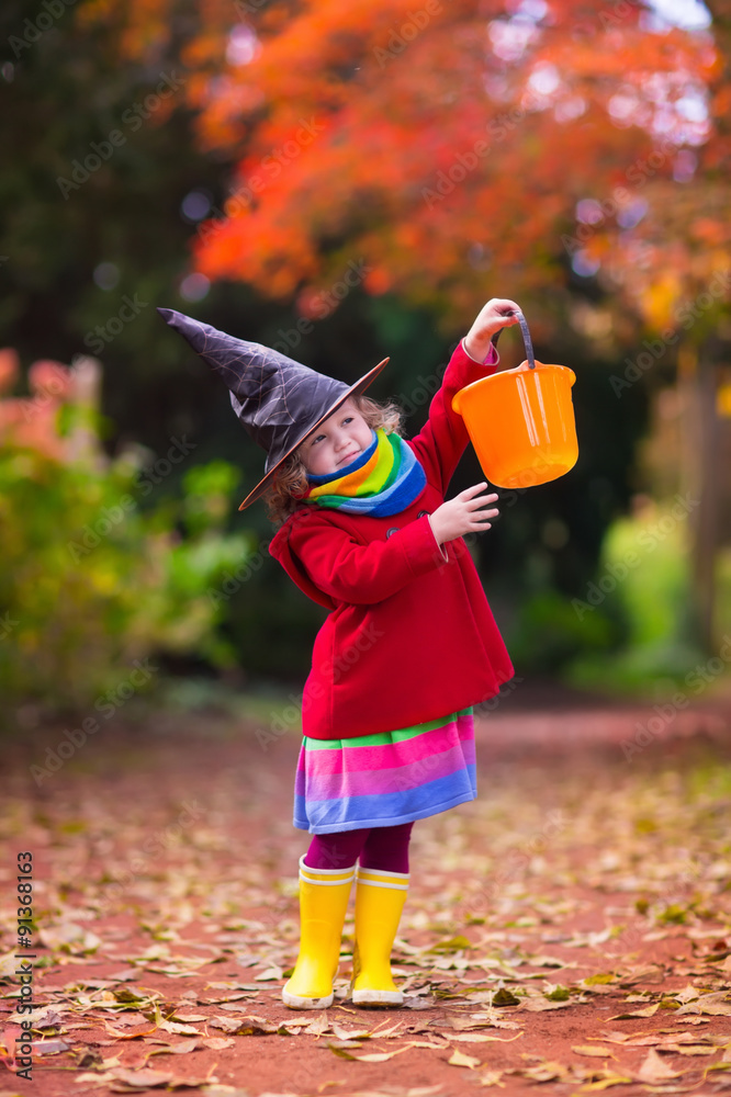 Obraz premium Little girl in witch costume at Halloween