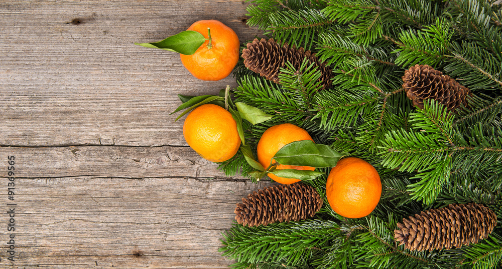 Mandarine fruits and christmas tree branches on wooden backgroun Mandarine fruits and christmas tree branches on wooden backgroun