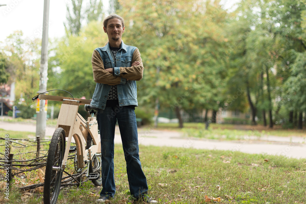 Hipster man with his cruiser wooden handmade bike Hipster man with his cruiser wooden handmade bike