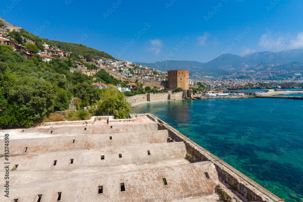 Red Tower (Kizil Kule) and the ruins of the fortress wall near the shore. The Mediterranean coast. Alanya. Turkey