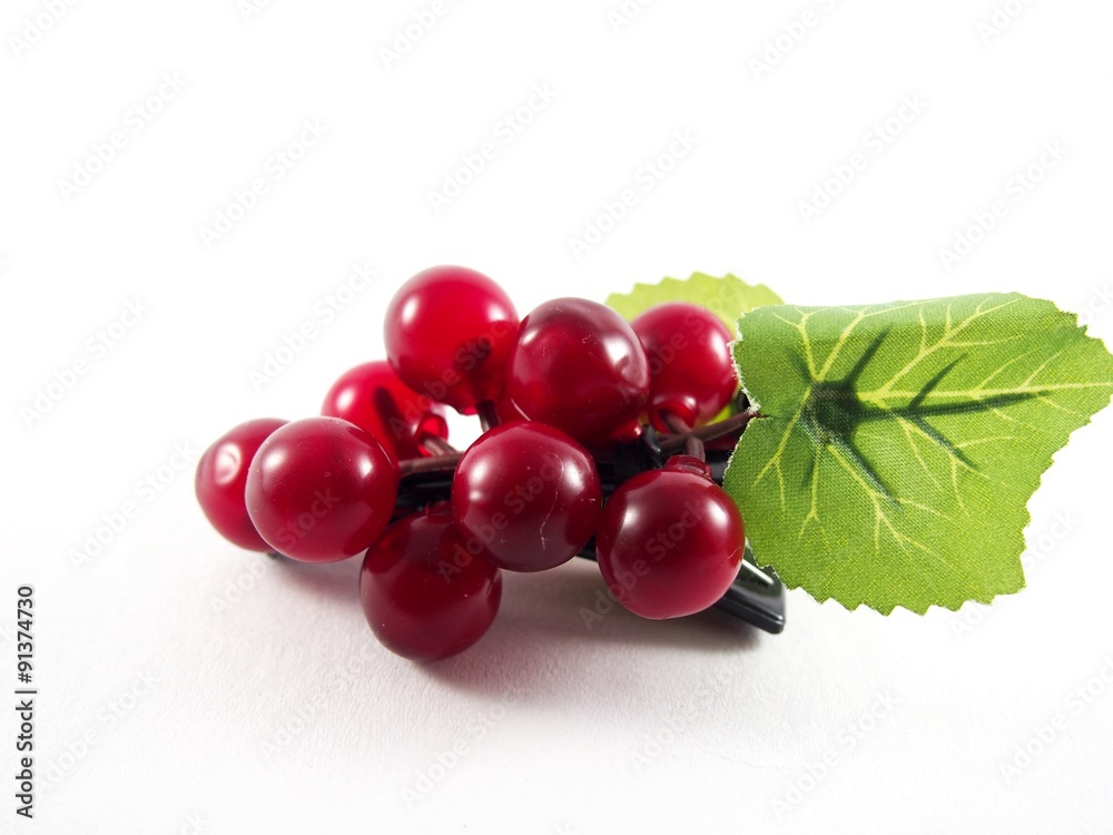 Purple plastic grape fruit shape on black hairpin, decorated with artificial green leafs, hair accessory, isolated on white background Purple plastic grape fruit shape on black hairpin, decorated with artificial green leafs, hair accessory, isolated on white background