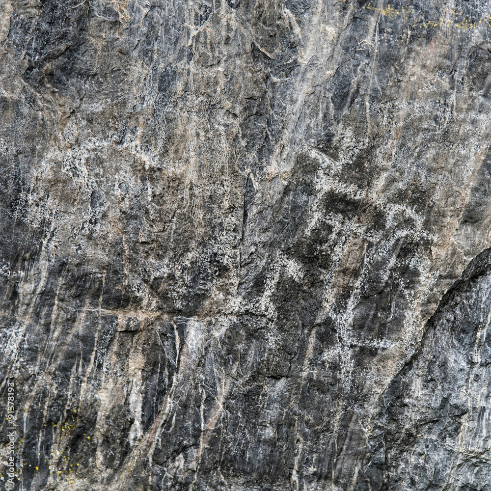 Fototapeta premium Ancient Primitive Petroglyphs on Black Rock Stone