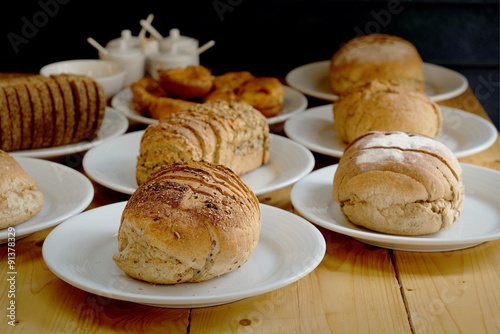 Baked bread on white plate and wooden table with Selective focus.