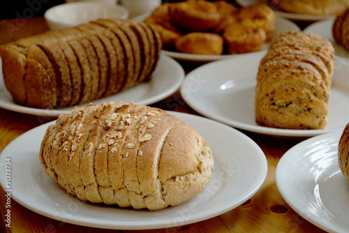 Baked bread on white plate and wooden table with Selective focus.