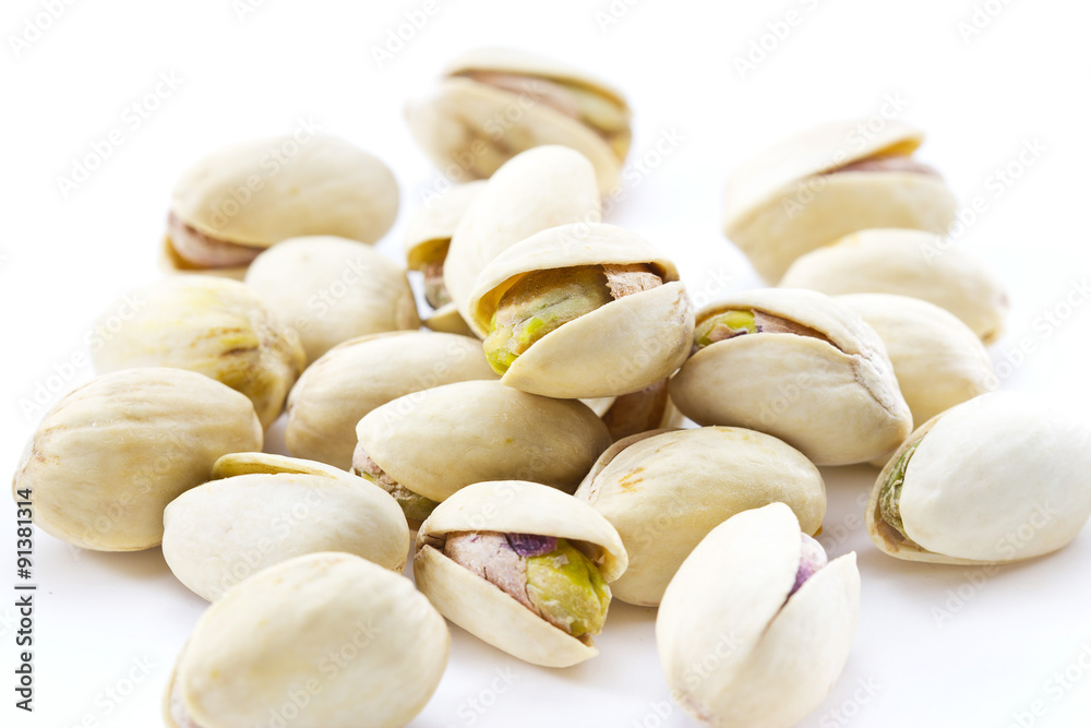 heap salted pistachio nuts on wooden spoon background, soft focus heap salted pistachio nuts on wooden spoon background, soft focus
