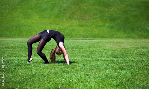 Young gymnast on grass in sunny day
