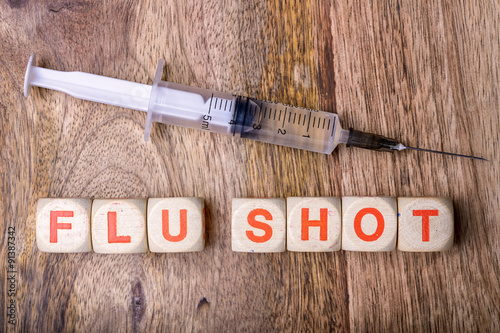 flu shot written with syringe on wood