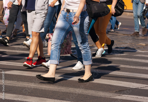 feet of pedestrians walking on the crosswalk