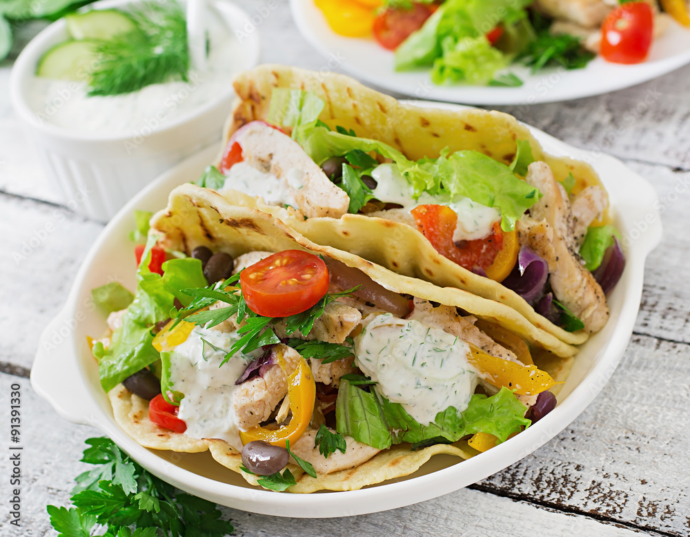 Mexican tacos with chicken, bell peppers, black beans and fresh vegetables and tartar sauce Mexican tacos with chicken, bell peppers, black beans and fresh vegetables and tartar sauce