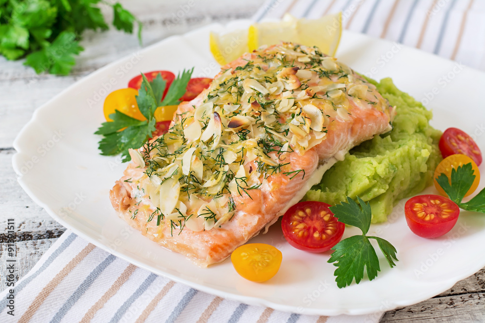 Baked salmon with cheese and almond crust and garnished with mashed potatoes and green peas Baked salmon with cheese and almond crust and garnished with mashed potatoes and green peas
