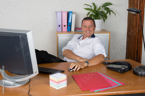 Manager man at his desk at work photo