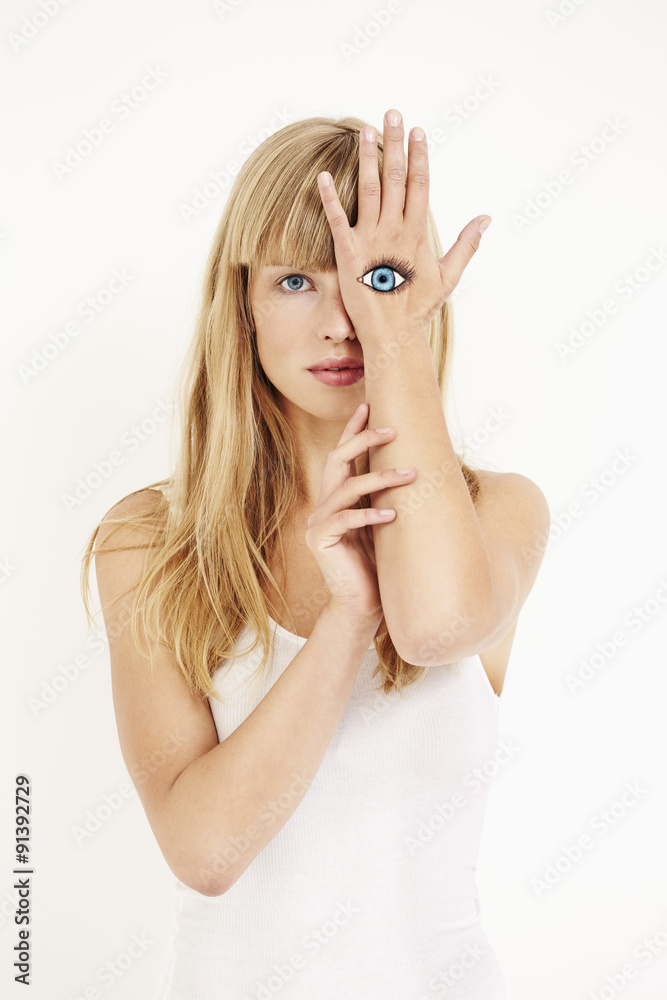 Painted eye on gorgeous blond woman in studio